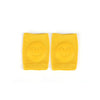 A pair of bright yellow knitted knee pads for crawling infants, each featuring a smiling face.