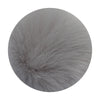 A round pom pom made of soft gray faux fur with a silver chain attached.