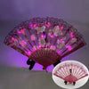 A folding fan with a purple and pink translucent design featuring floral patterns and glowing lights.