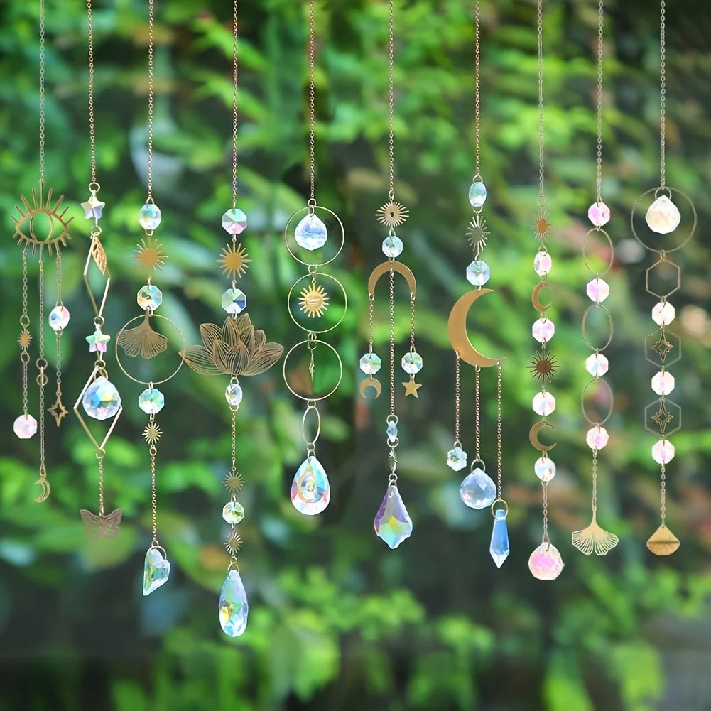Un conjunto de colgantes y charms de cristal coloridos colgados de cuerdas contra un fondo verde desenfocado.