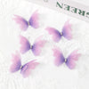 Pink and purple embroidered butterfly patches with small rhinestones on white fabric