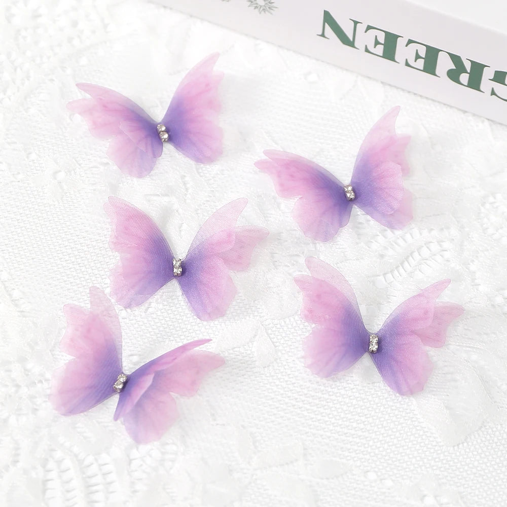 Pink and purple embroidered butterfly patches with small rhinestones on white fabric