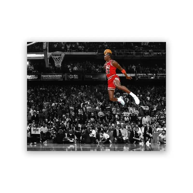 A photo of a basketball player in a red jersey attempting a slam dunk during a game.