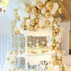 A decorative display featuring white and gold confetti balloons arranged in a tiered structure.