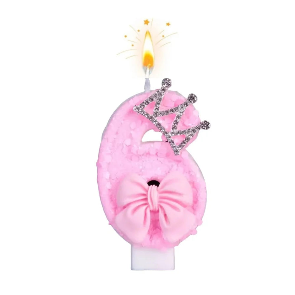 Pink bow crown number birthday candles set with a lit candle and sparkling crown detail