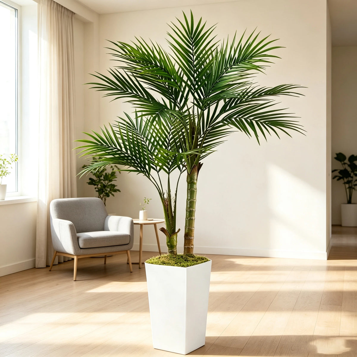 A tall artificial areca palm tree in a white planter stands in a bright, modern room.