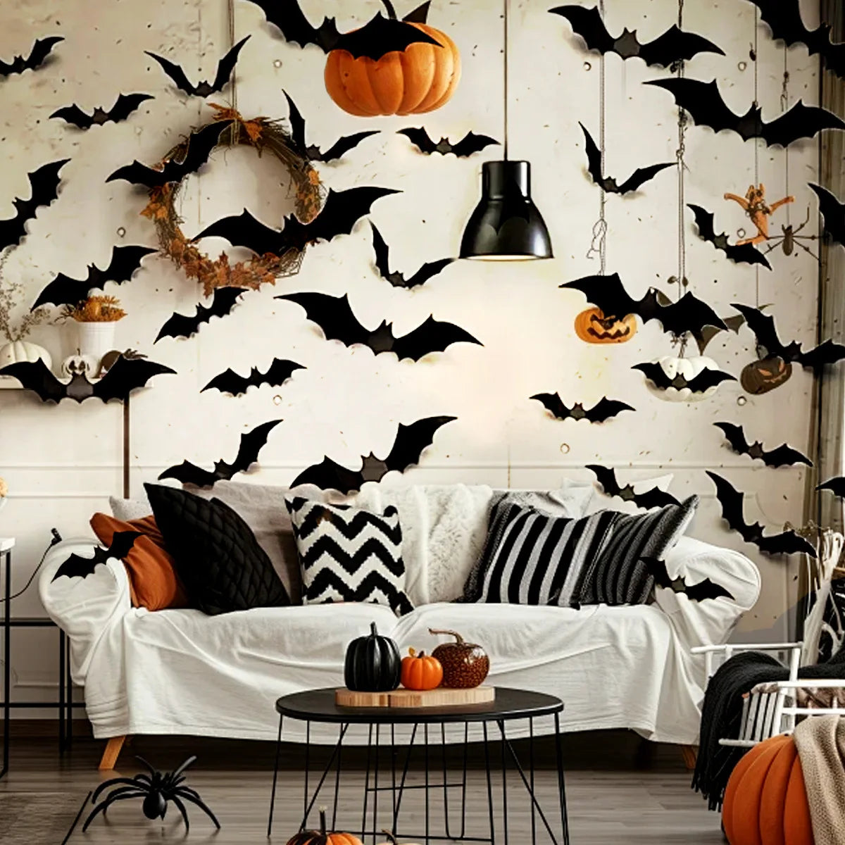 A white wall decorated with black bat silhouettes and a carved pumpkin, featuring a sofa and decorative elements.