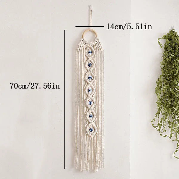 Cream macrame wall hanging with a long fringe and multiple blue evil eye pendants
