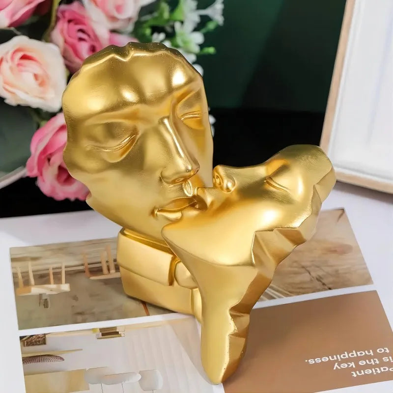A golden resin sculpture depicting an abstract kissing couple.