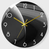 A black round wall clock with gold hands showing a time close to 10 o'clock.