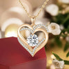 Gold heart pendant necklace featuring a clear diamond stone and surrounding pave diamonds, displayed on a red box.