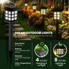 A black solar outdoor light fixture with a square panel is shown in a garden setting.