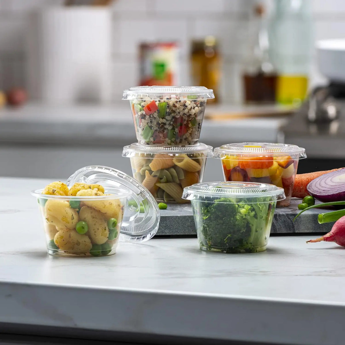 A collection of clear disposable plastic bowls with lids filled with various colorful fresh ingredients like vegetables and g
