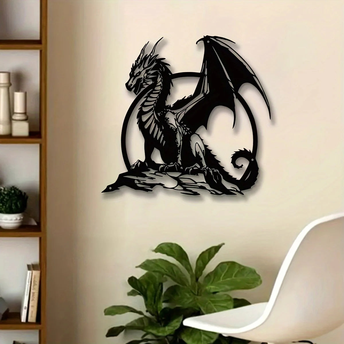 A black metal wall sculpture of a dragon with large wings set against a light beige wall.