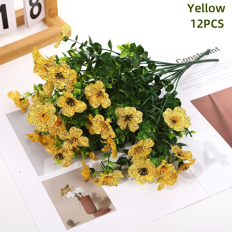 Yellow artificial daisy flower bundles in a green foliage arrangement