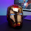 A metallic gold and red Iron Man helmet with blue LED eyes is displayed on a dark surface.