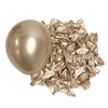 A single metallic gold latex balloon next to a pile of crumpled metallic gold foil balloons.