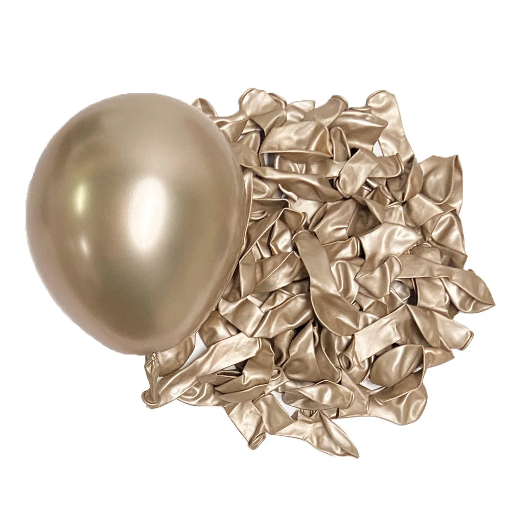 A single metallic gold latex balloon next to a pile of crumpled metallic gold foil balloons.