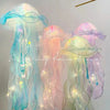 Three glowing jellyfish lanterns with iridescent blue, pink, and green hues hanging in the air.
