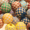 A collection of natural wooden checkered beads in various colors including green, orange, blue, and yellow.