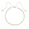 Handmade boho glass bead bracelet with adjustable cord featuring small gray and gold beads.