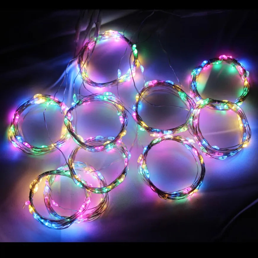 A collection of glowing LED curtain fairy lights in various colors forming circular shapes against a dark background.