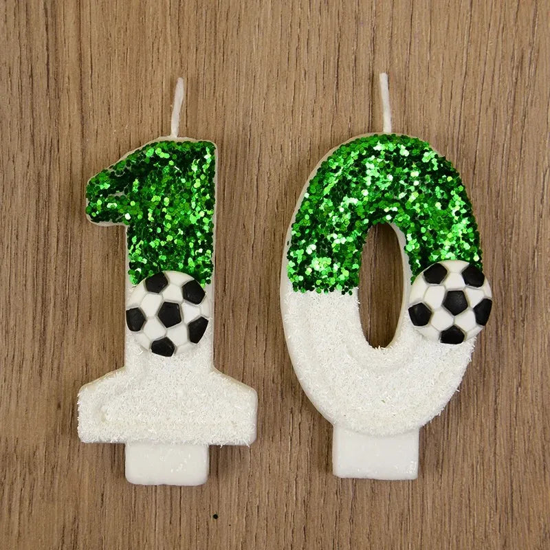 Two white candles shaped like the numbers 1 and 0 decorated with green glitter soccer balls