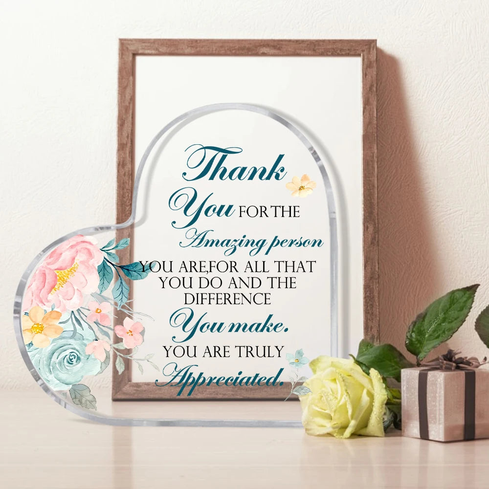 A framed acrylic heart sign with a floral wreath design and elegant script thanking someone for their difference.