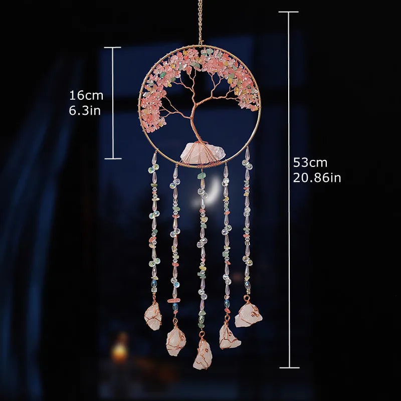 A hanging crystal tree of life sun catcher featuring pink and white floral elements and dangling crystals.