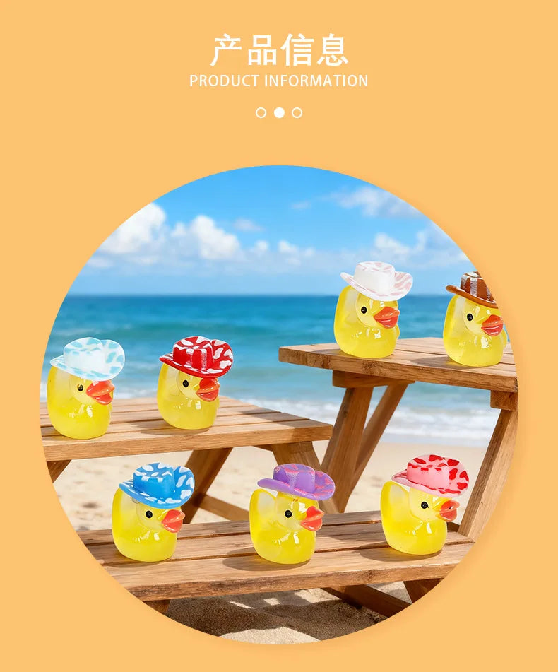 A set of glow-in-the-dark resin duck figurines with colorful hats sitting on a wooden deck near the ocean.