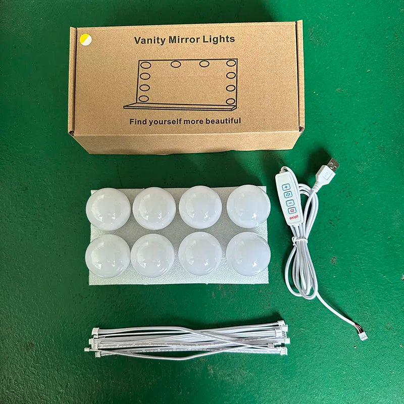 A box of vanity mirror lights with a diagram, along with loose LED strips and wiring.