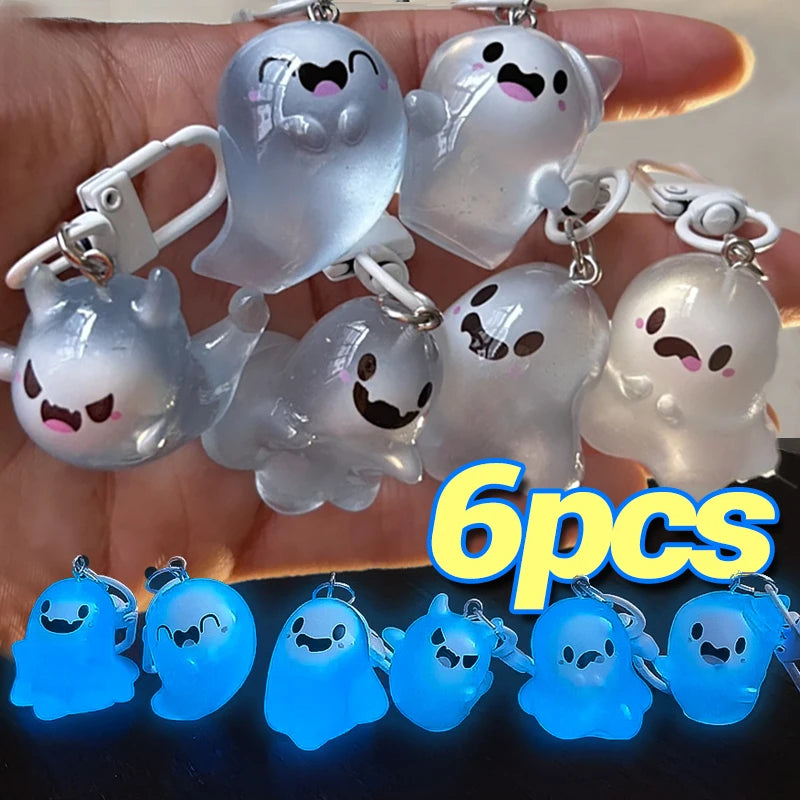 Six glow-in-the-dark ghost keychains are displayed in a hand, with several blue and white ghostly figures visible.