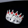 A silver crystal rhinestone crown with red gemstones and intricate detailing.