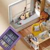 A hand holds a purple book display featuring various books and a guitar in a room setting.