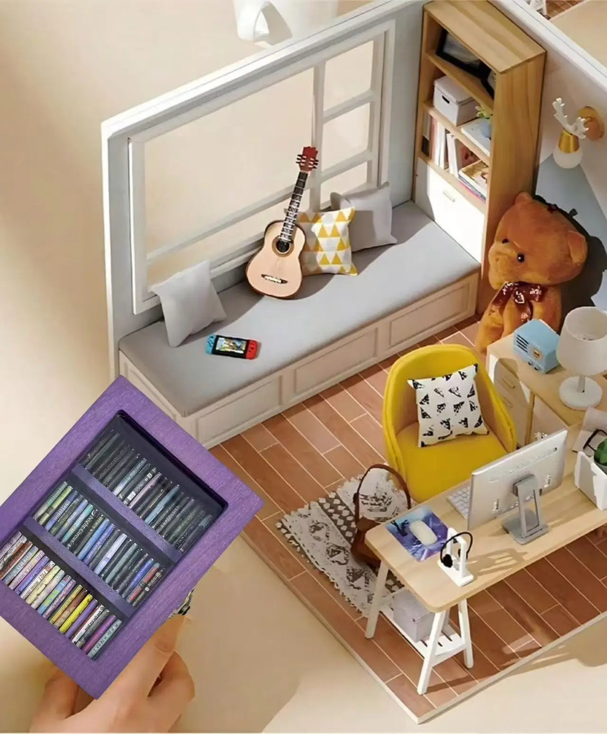 A hand holds a purple book display featuring various books and a guitar in a room setting.