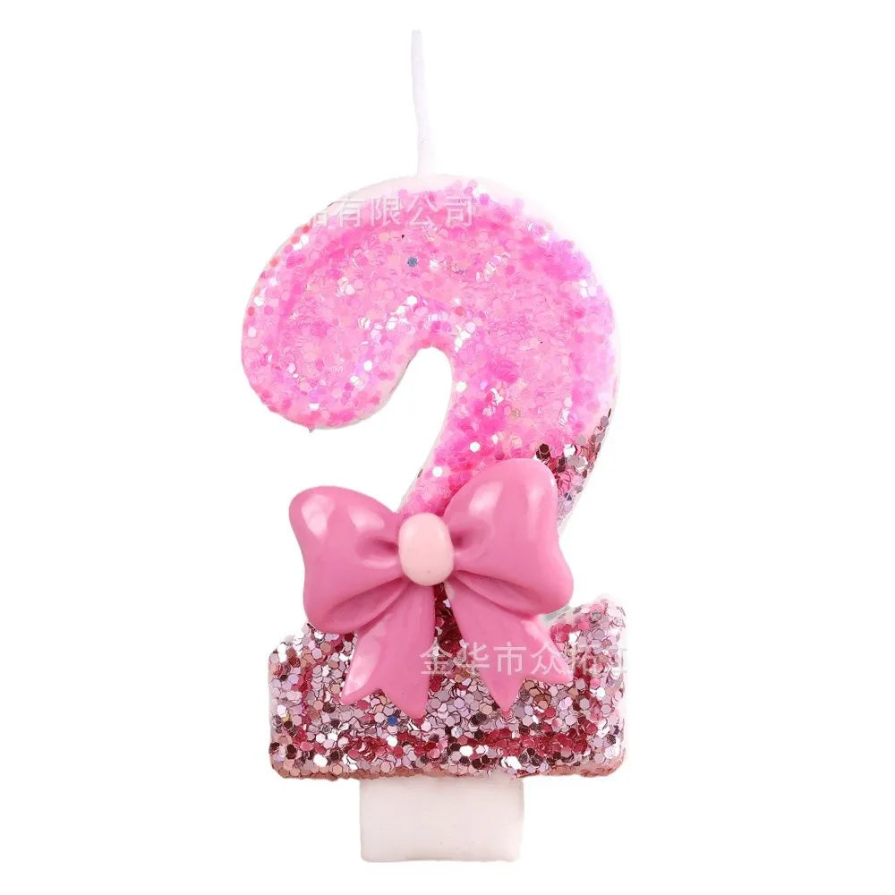 A pink sequin bow decorative birthday candle shaped like the number nine