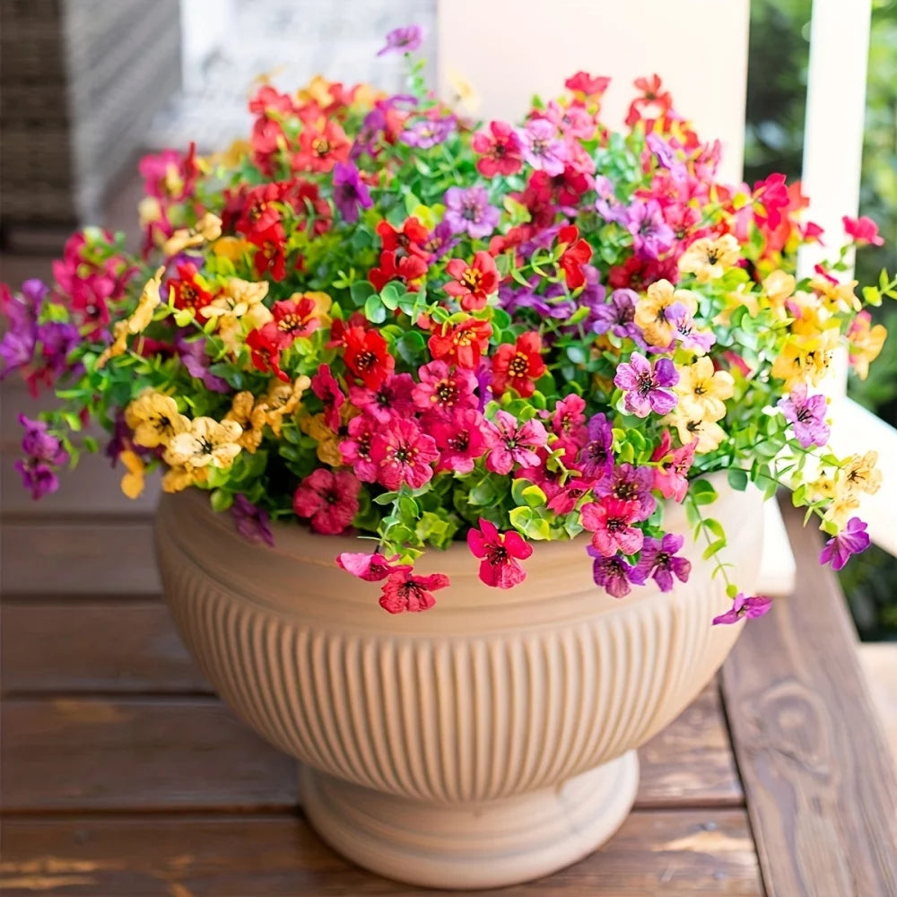 A vibrant bouquet of mixed artificial daisy flower bundles in shades of pink, red, yellow, and purple displayed in a terracot