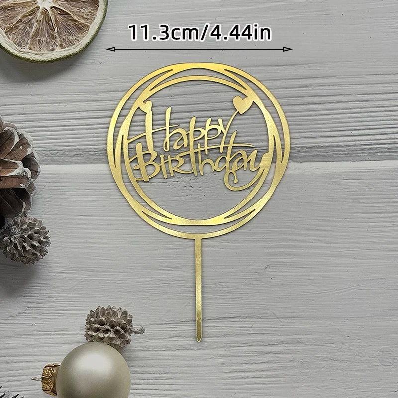A gold acrylic birthday cake topper with the words Happy Birthday on a circular design.
