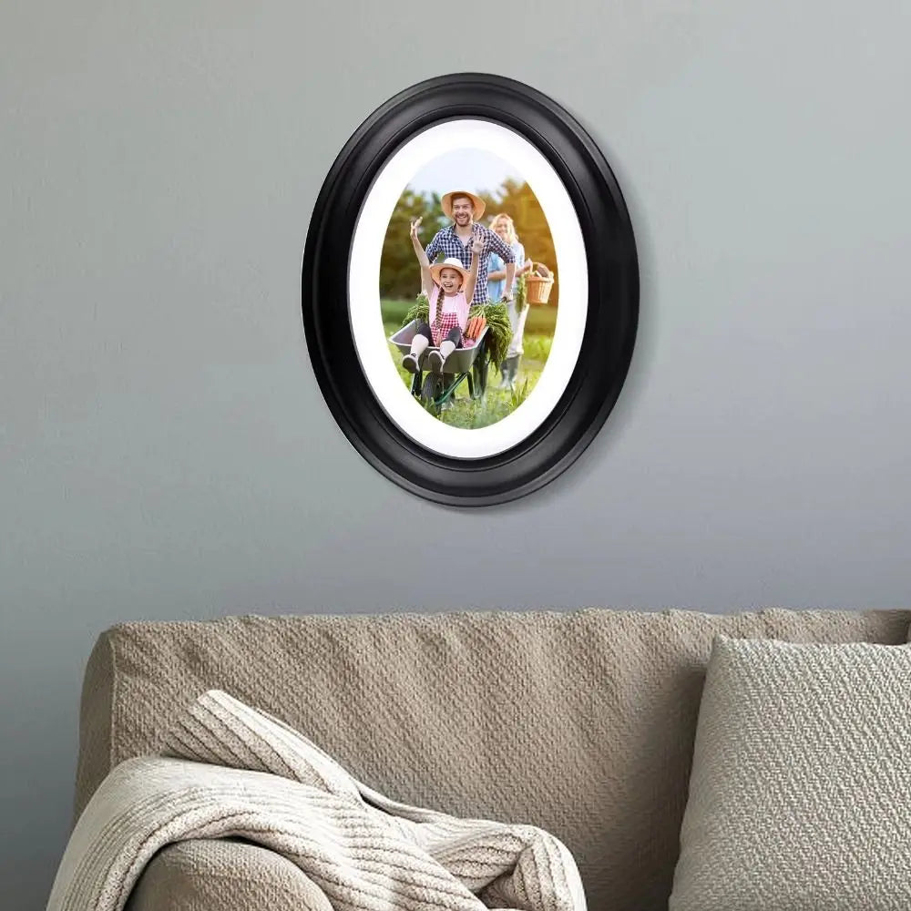 A black oval picture frame displaying a photo of a family outdoors.