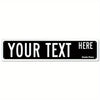 A rectangular black metal sign with white text that reads YOUR TEXT HERE
