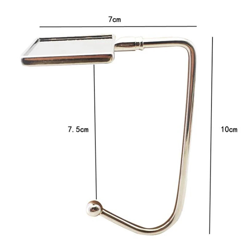 A silver foldable handbag hook with a rectangular clip and a curved wire handle.