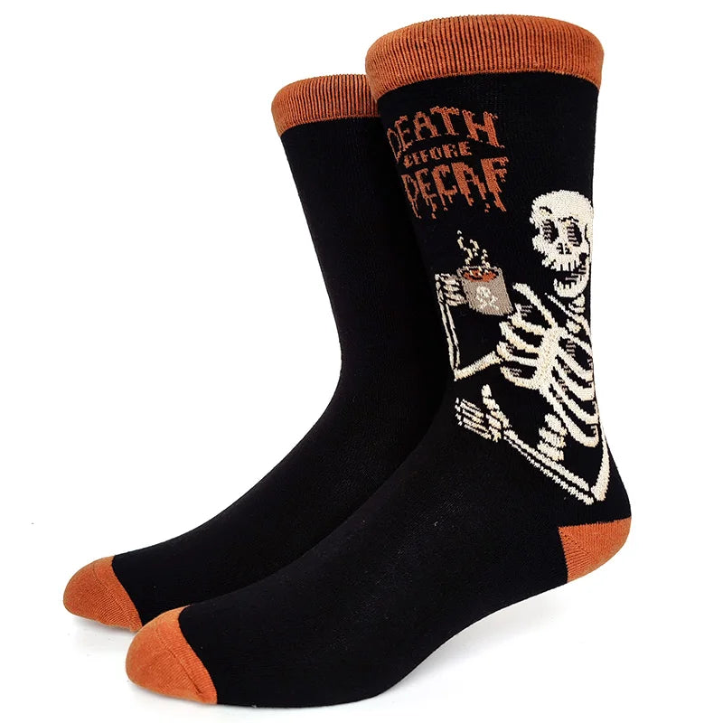 A pair of black crew socks with an orange cuff featuring a graphic design of a skull and skeleton.