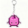 A pink pixel art charm of a Junimo character attached to a silver keychain ring.
