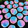 Iridescent blue and pink crystal geodes displayed in a dark tray for home decor