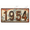A vintage, weathered aluminum license plate tag displaying the year 1954.