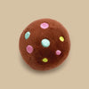 A round brown plush toy resembling a chocolate chip cookie with colorful dots.