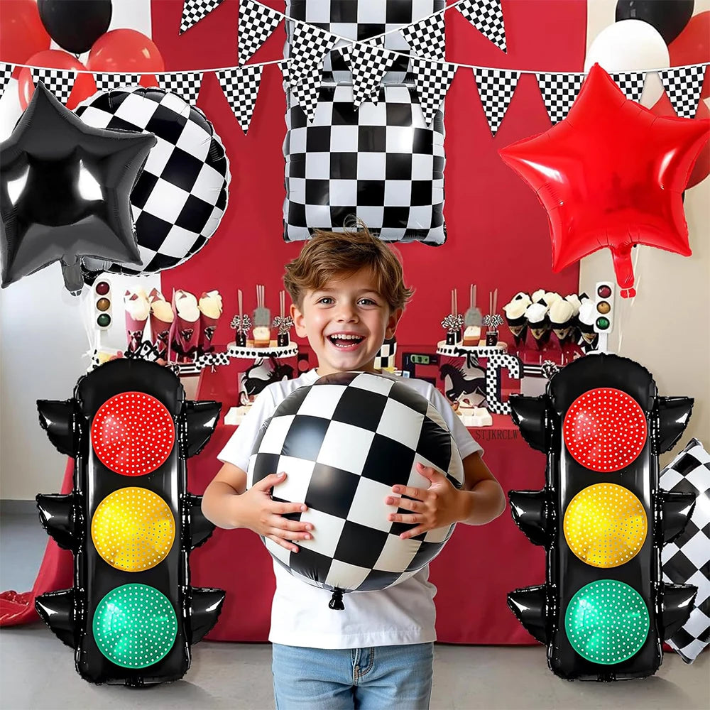 A child holds a black and white checkered race car traffic light balloon set against a red background.