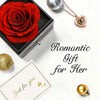 Un coffret cadeau romantique avec une rose rouge conservée et un collier doré sur fond blanc.