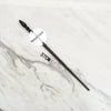 A black metal magic wand replica lying on a white marble surface.