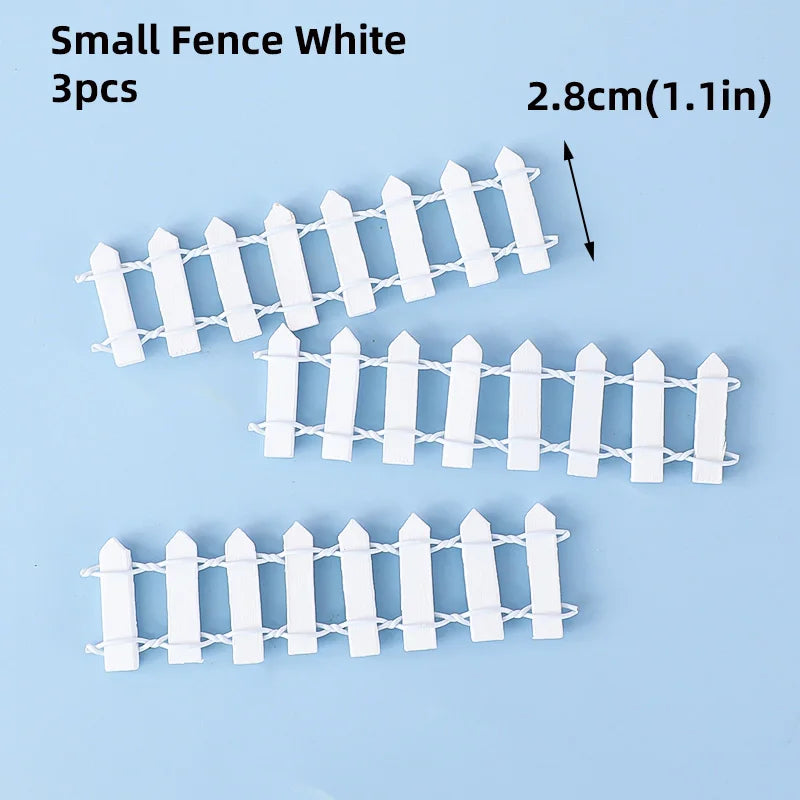 Three white picket fence cake toppers, 2.8cm long, for birthday parties.